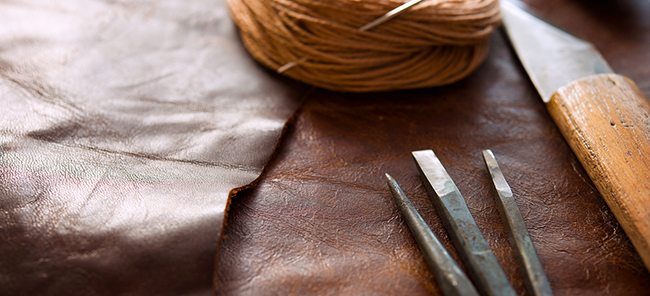 Leather craft.  Leather and leather crafting tools on a work tab
